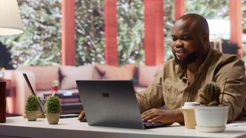 Freelancer using his laptop to manage business analytics and financial planning, ensuring successful telecommuting. Working on budget and project development from his home office. Camera B. video