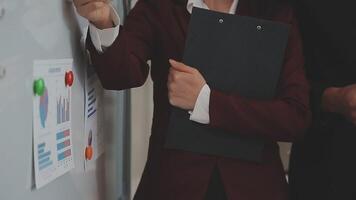 Group of casually dressed asian businesspeople discussing ideas in the office. Creative professionals gathered at the meeting table for discuss important issues of the new successful startup project video