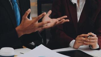 Group of casually dressed asian businesspeople discussing ideas in the office. Creative professionals gathered at the meeting table for discuss important issues of the new successful startup project video