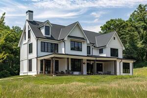 A large white house with a black roof and black trim photo