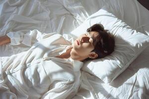Asian man 20 yo in a white clothes laying down on white bed with white blanket, happily sleeping photo