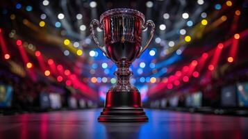A silver trophy sits on a polished surface in the middle of an arena, illuminated by red and blue lights photo