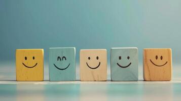 Five wooden blocks, each with a different happy face, lined up in a row against a light blue background photo