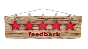 A weathered wooden sign with five red stars and the word feedback written in bold red letters photo