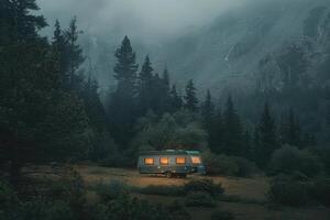 A caravan parked in a tranquil forest setting with misty mountains in the background during twilight photo