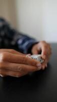 In this image, hands are shown playing with dice on a black table in a closeup view video