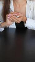 A woman is sitting at a table with dice, exuding calmness and concentration while engaged in a game video