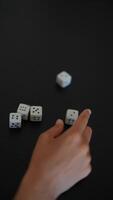 A group of people intensely playing a dice game under the soft glow of a lamp on the table video