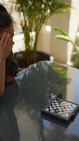 Woman concentrating on a chess game outside, enjoying a leisure activity in the open air video
