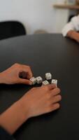 At the table, a woman is deeply involved in a dice game, showing enjoyment and concentration video