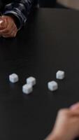 In the image, a person is intensely engaged in playing a dice game, showing focus and concentration video
