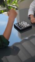 Miniature chess game on table for players to compete and strategize under sunlight video