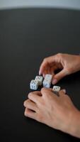 People engage in indoor recreation by playing games or rolling dice on a table for fun video