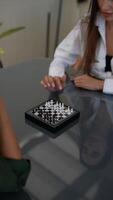 An intense chess game match is taking place between two players in a modern interior setting video