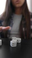 Person playing dice at black table, focusing on rolling dice with hands showing luck and strategy video