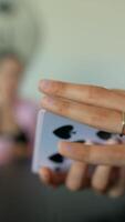 Hands are actively participating in a card game while closely gathered in a circle video