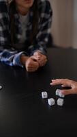 Friends are gathered around a table, immersed in a lively game of dice in a closeup shot video