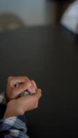 A group of people is gathered around a dark table, engaging in a board game using dice video