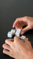 Closeup shots of hands rolling dice on a dark table, capturing different aspects of gaming video