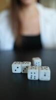 A pair of hands is seen rolling dice on a table indoors, possibly during a board game session video