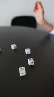 A detailed photograph capturing hands rolling dice in the midst of a gaming session video