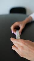 A person indoors engaging in activities of rolling dice and using a tablet stylus video