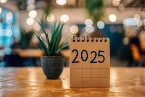 A notepad depicting the year 2025 with a plant in the background photo