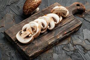 Sliced mushrooms on a wooden cutting board photo