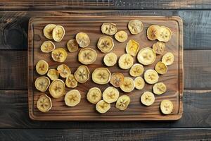 Dried banana slices on wooden cutting board photo