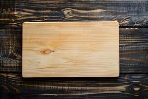 Plain wooden cutting board on dark wooden background photo