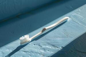 White toothbrush on a blue surface in sunlight photo