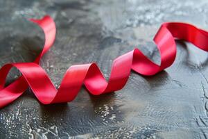 Red ribbon on textured dark surface photo
