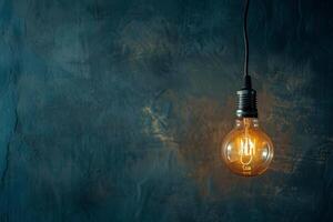 Glowing vintage light bulb against dark teal textured background photo