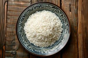 Rice in a decorative bowl on a wooden table photo