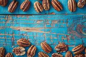 Pecans scattered on a rustic blue wooden surface photo