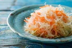 Close-up of sauerkraut with carrots on a blue plate photo