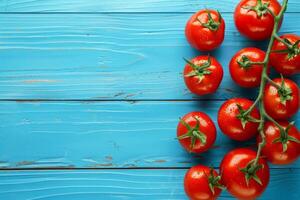 Bright red tomatoes on a branch arranged on a shabby blue wooden background photo