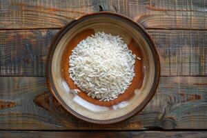 Rice in a brown ceramic bowl on a wooden table photo