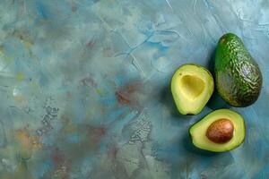 Whole and halved avocados on a table, top view photo