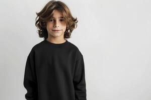 Cute boy in a black sweatshirt on a gray background. Kids sweatshirt mockup. photo
