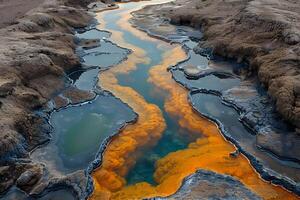 Vibrant Volcanic Hot Spring Stream with Colorful Mineral Deposits in Rugged Terrain photo