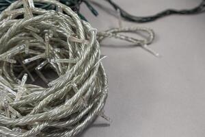String Christmas lights storage. Neatly wrapped up garlands on beige background with space for text photo