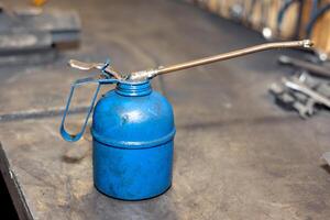 Blue oil can on the table in the workshope. photo