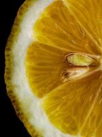Lemon cut. Lemon slice with seed on a black background photo