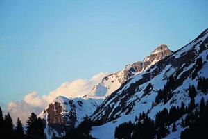 Blue Snowy Mountain Peaks with Clouds in Lec, Austria photo