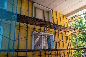 A close-up of a building exterior with insulation and scaffolding photo