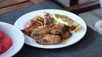 full plate on the table with variety of dishes in the all inclusive hotel restaurant,grilled chicken wings, Turkish flatbread with meat,battered fish, you can try whatever your heart desires video