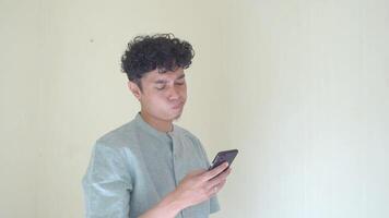 Moslem Asian man click smartphone and texting gesture when Ramadan celebration. The footage is suitable to use for business Ramadhan poster and Muslim content media. video