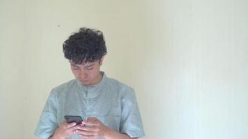 Moslem Asian man click smartphone and texting gesture when Ramadan celebration. The footage is suitable to use for business Ramadhan poster and Muslim content media. video