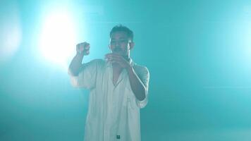 Man dancing in bright lights with blue-green tint video